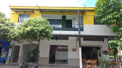 a yellow and white building with a motorcycle parked in front at Como en casa 2 in La Dorada