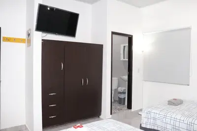 a bedroom with a dresser with a flat screen tv on a wall at Como en casa 2 in La Dorada