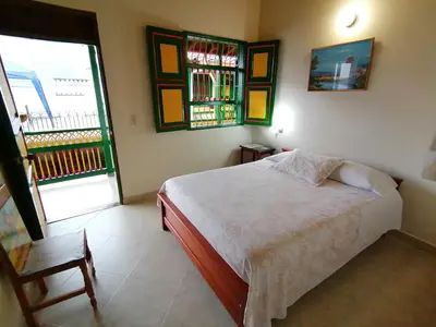 a bedroom with a white bed and a window at Balcones del Parque Jardin in Jardin