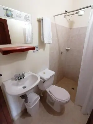 a white bathroom with a toilet and a sink at Balcones del Parque Jardin in Jardin