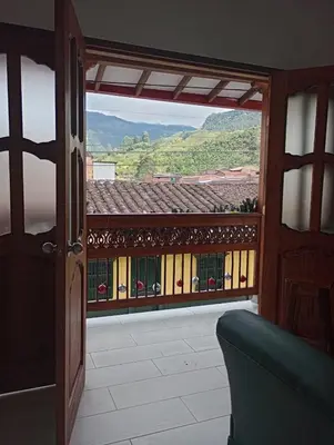 an open door to a balcony with a view at Hostal Famihotel Fundadores in Jardin