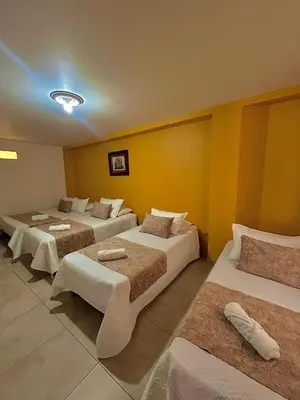 a hotel room with three beds and yellow walls at Hotel Dorado Jardín in Jardin