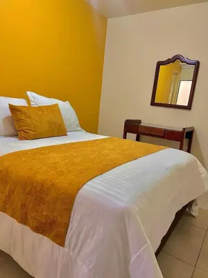 a bedroom with a large bed and a mirror at Hotel Dorado Jardín in Jardin