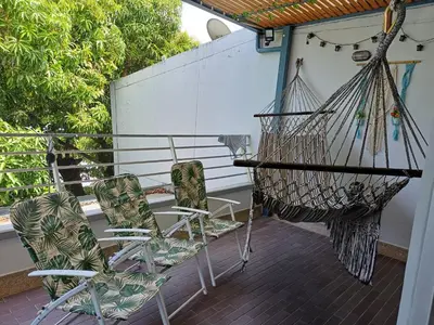 two chairs and a hammock on a porch at Apartamento 2 habitaciones aire acondicionado en Sopetran Unidad res Piscinas sol y descanso in Sopetran