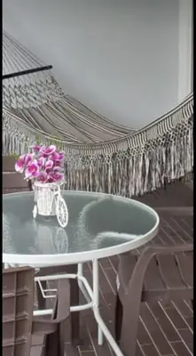 a table with a vase of pink flowers on it at Apartamento 2 habitaciones aire acondicionado en Sopetran Unidad res Piscinas sol y descanso in Sopetran