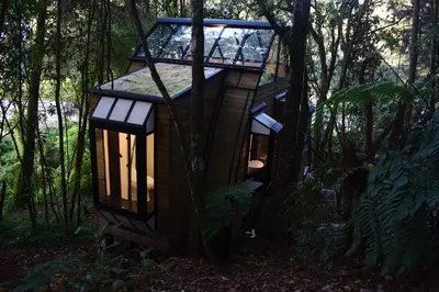 a tree house in the woods with lights on it at Chalet Tanat in Santa Elena