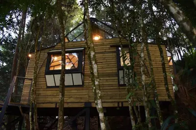 a tree house in the woods with windows at Chalet Tanat in Santa Elena