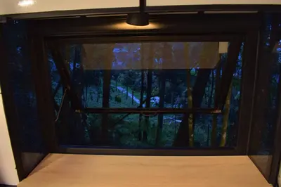 a bedroom window with a view of a forest at Chalet Tanat in Santa Elena