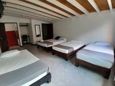 a room with three beds in a room at Hotel Palermo Real in Medellín