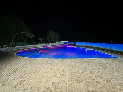 a large swimming pool lit up at night at occidente colonial santa fe de Antioquia tipo resort Aparta sol tobogán kanaloa parque acuático in Santa Fe de Antioquia