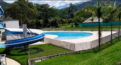 a large swimming pool with a blue water slide at occidente colonial santa fe de Antioquia tipo resort Aparta sol tobogán kanaloa parque acuático in Santa Fe de Antioquia