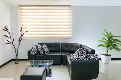 a living room with a black couch and a window at Super Apartment El Poblado Tesoro 2 rooms, 3 baths - 6 guests in Medellín