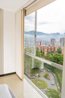 a large window with a view of a city at Super Apartment El Poblado Tesoro 2 rooms, 3 baths - 6 guests in Medellín