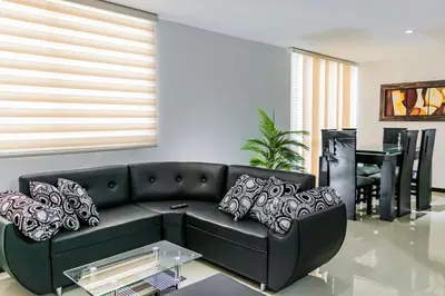 a living room with a black couch and a table at Super Apartment El Poblado Tesoro 2 rooms, 3 baths - 6 guests in Medellín
