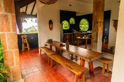 a dining room with a wooden table and benches at Aldea Sabatinga in Manizales