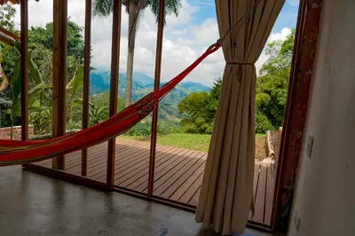 a hammock in a room with a view of the mountains at Aldea Sabatinga in Manizales