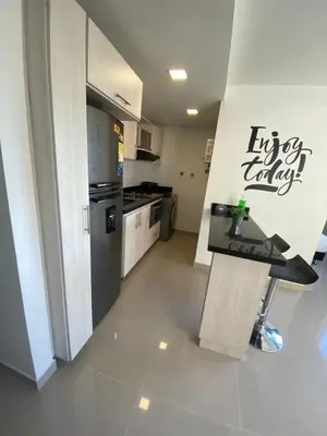 a kitchen with a refrigerator and a counter in a room at 712 Apartasuite moderna - en el corazón del poblado medellín in Medellín