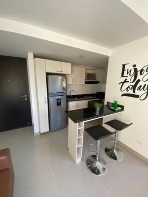 a kitchen with a black counter and a refrigerator at 712 Apartasuite moderna - en el corazón del poblado medellín in Medellín
