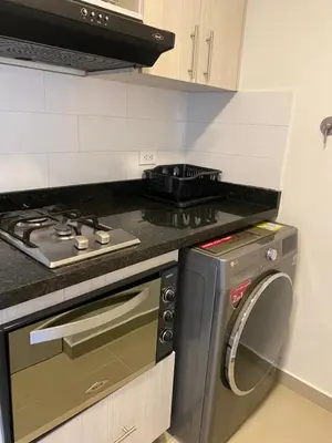a kitchen with a stove and a washing machine at 712 Apartasuite moderna - en el corazón del poblado medellín in Medellín
