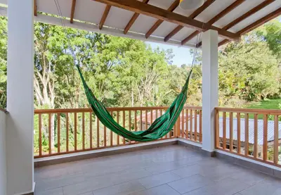 a hammock on the front porch of a house at Glamping Jardín in Jardin