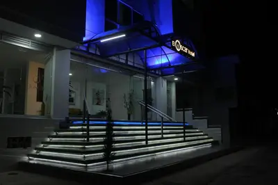a lit up building with stairs in front at night at El Oscar Hotel in Medellín