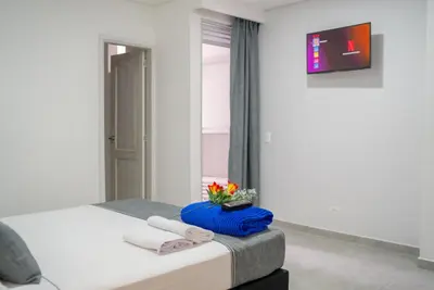 a bedroom with a bed with towels and a mirror at El Oscar Hotel in Medellín