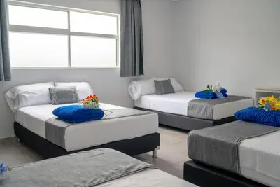 a room with three beds and a window at El Oscar Hotel in Medellín