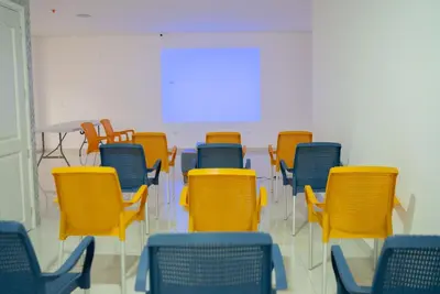 an empty room with yellow and blue chairs at El Oscar Hotel in Medellín