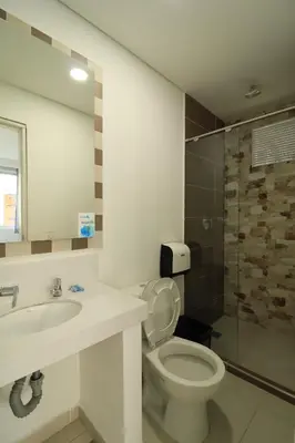 a bathroom with a toilet and a sink and a shower at El Oscar Hotel in Medellín