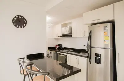 a kitchen with white cabinets and a stainless steel refrigerator at Elegante Apto en el Poblado! Vista Fabulosa in Medellín