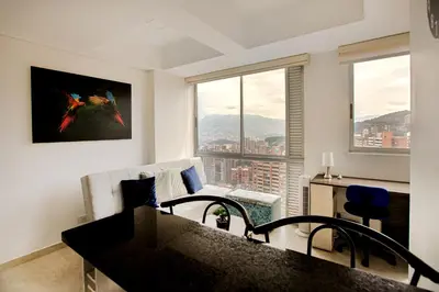 a kitchen and living room with a view of a city at Elegante Apto en el Poblado! Vista Fabulosa in Medellín