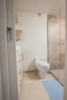 a bathroom with a toilet and a glass shower at Elegante Apto en el Poblado! Vista Fabulosa in Medellín