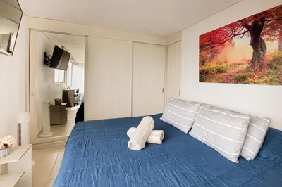 a bedroom with a blue bed with white pillows at Elegante Apto en el Poblado! Vista Fabulosa in Medellín