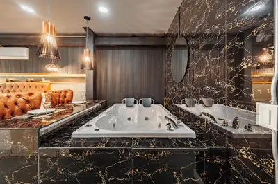 a bathroom with two sinks and a couch at One Apartments Laureles in Medellín