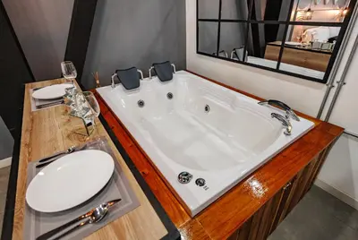 a bathroom with a tub with a toilet and a sink at One Apartments Laureles in Medellín