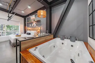 a large white tub in a room with a bed at One Apartments Laureles in Medellín