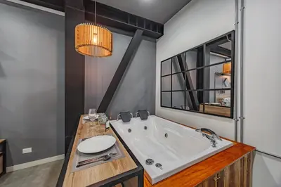 a bathroom with a large tub and a mirror at One Apartments Laureles in Medellín