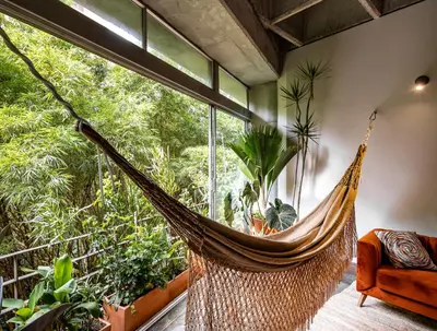 a hammock in a room with a large window at Soho Lofts by Vibra Bonita in Medellín