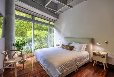 a bedroom with a bed and a large window at Soho Lofts by Vibra Bonita in Medellín