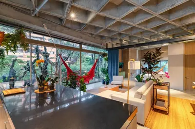 a large living room with a lot of plants at Soho Lofts by Vibra Bonita in Medellín