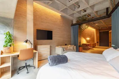 a bedroom with a bed and a desk and a tv at Soho Lofts by Vibra Bonita in Medellín