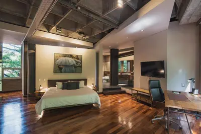 a bedroom with a bed and a desk and a television at Soho Lofts by Vibra Bonita in Medellín