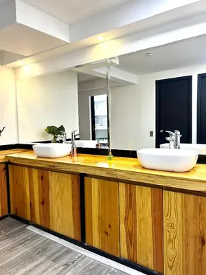 two sinks on a wooden counter in a bathroom at Orbe Hotel Medellín in Medellín