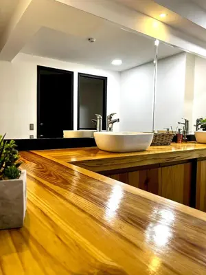 a bathroom with two sinks and a wooden counter at Orbe Hotel Medellín in Medellín