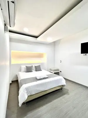a bedroom with a large bed and a flat screen tv at Orbe Hotel Medellín in Medellín