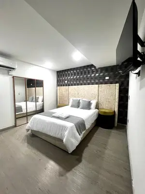 a bedroom with a large bed and two mirrors at Orbe Hotel Medellín in Medellín