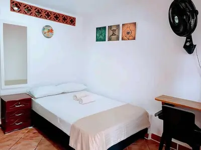 a bedroom with a bed and a desk and a fan at Petroglifo Room Támesis in Támesis