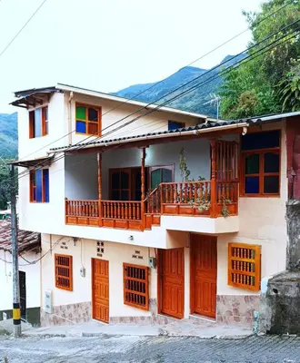 a house with wooden doors and a balcony at Petroglifo Room Támesis in Támesis
