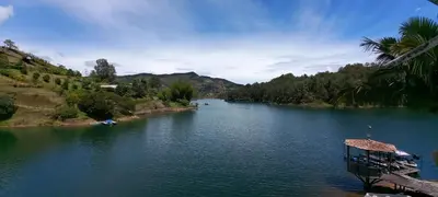 a river with a dock in the middle of it at Hotel Casa Linda Guatape in Guatapé