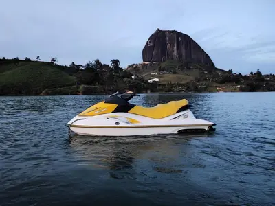 a yellow and white jet ski sitting in the water at Hotel Casa Linda Guatape in Guatapé